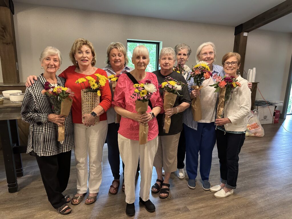 a group of women holding bouquets of flowers