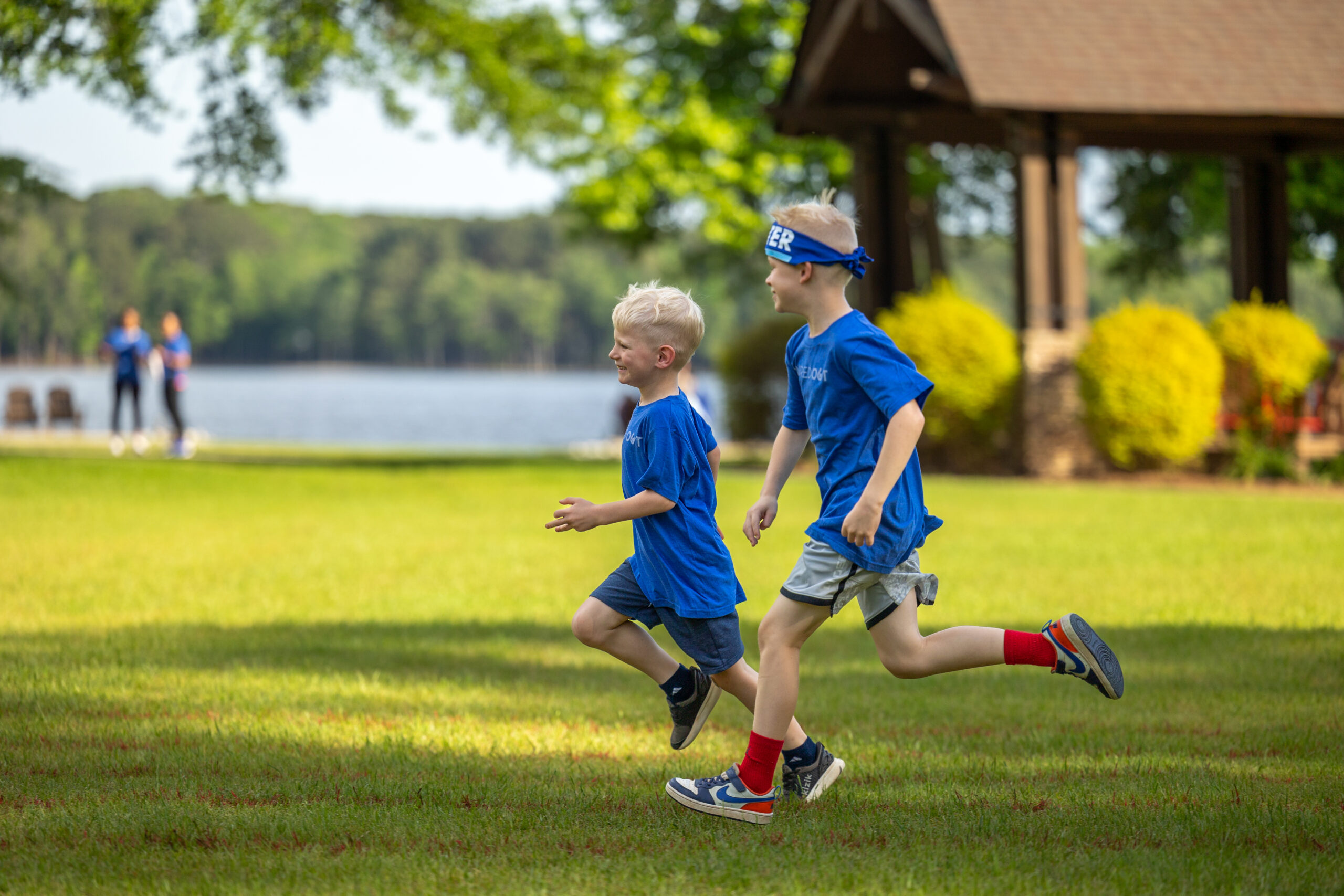 two kids running through a field