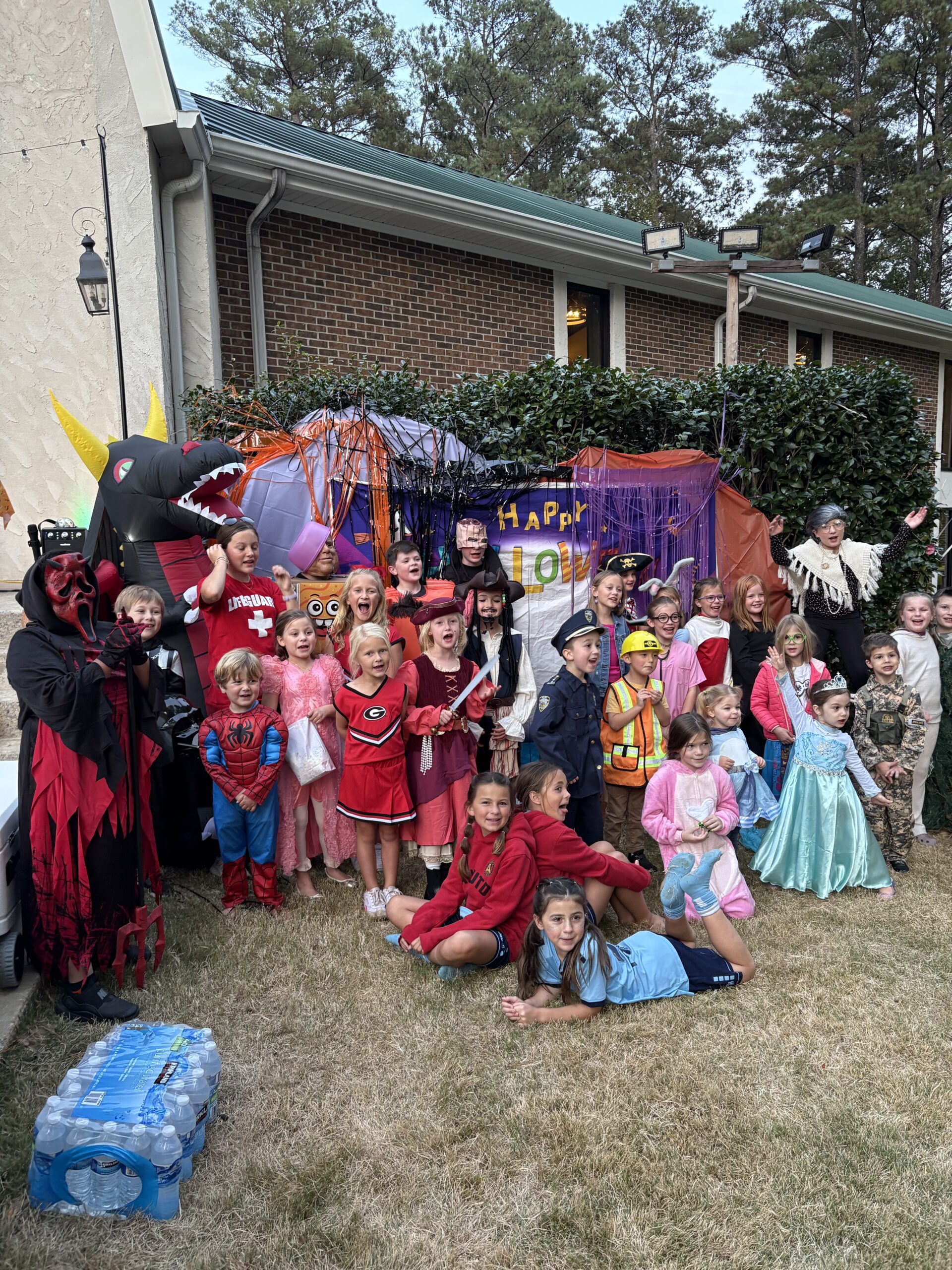 Kids in costume posing for a picture at an outdoor church event