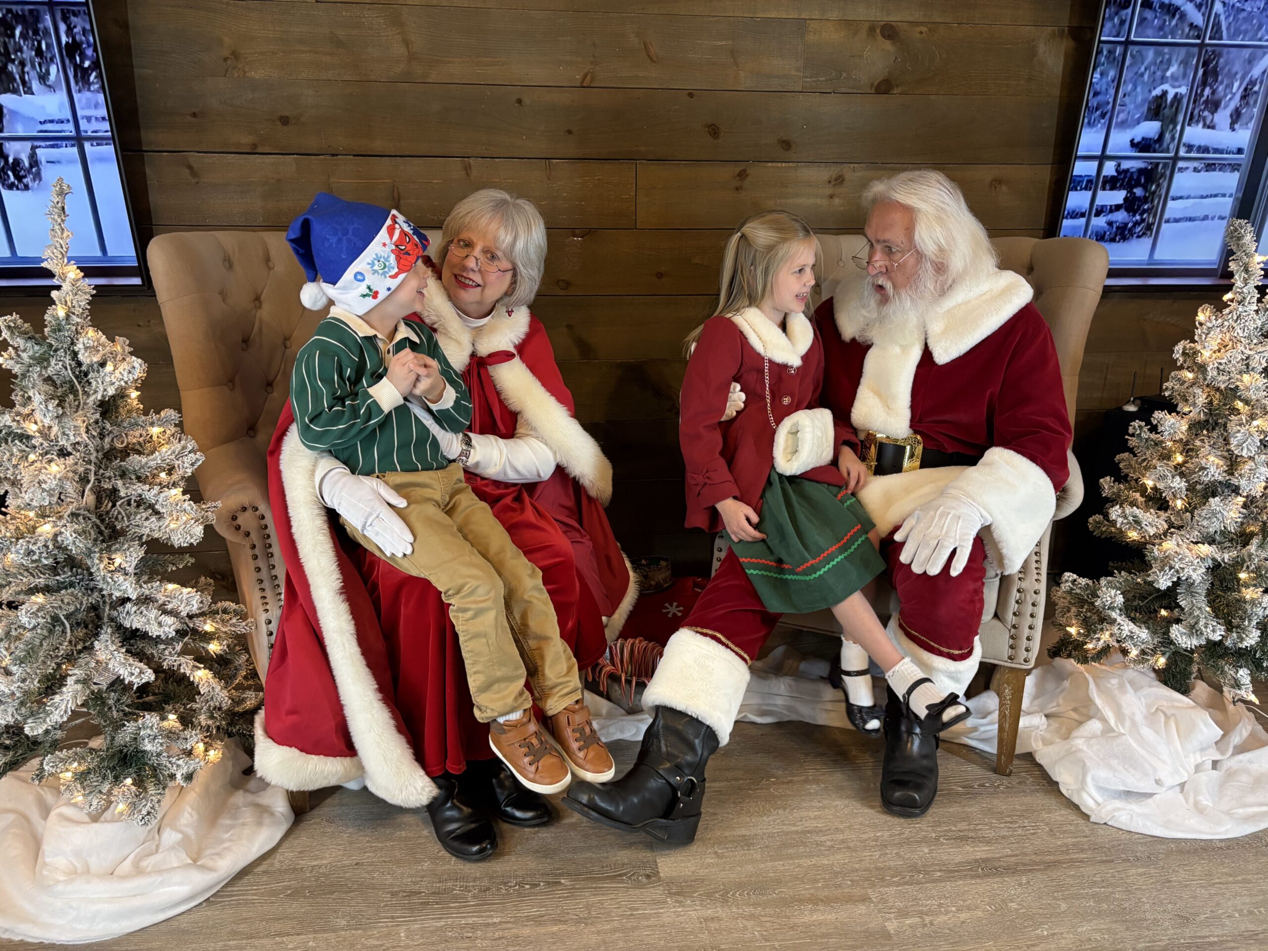 two kids sititng with santa and ms. claus